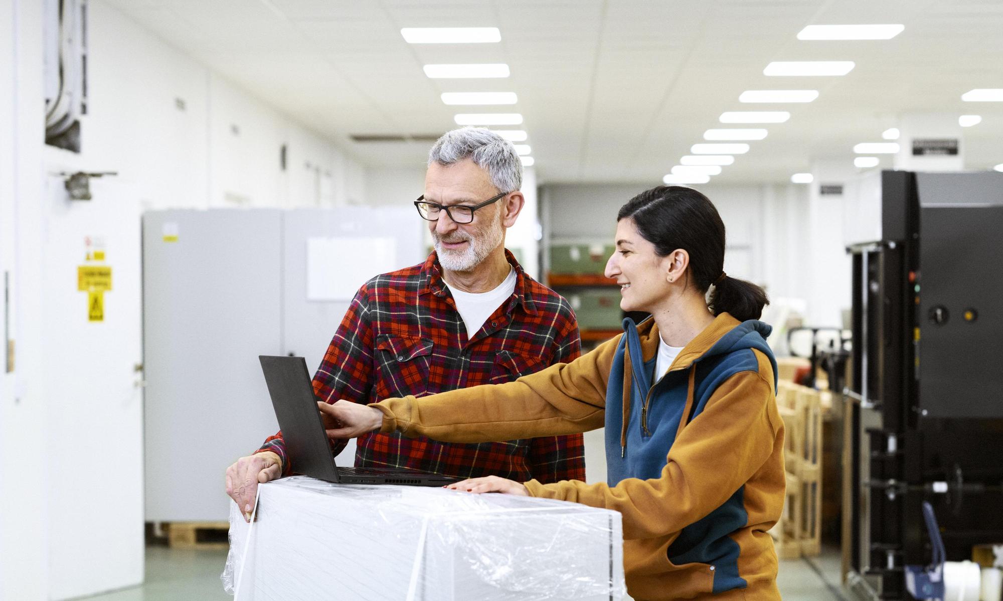 Two colleagues looking and pointing at a computer