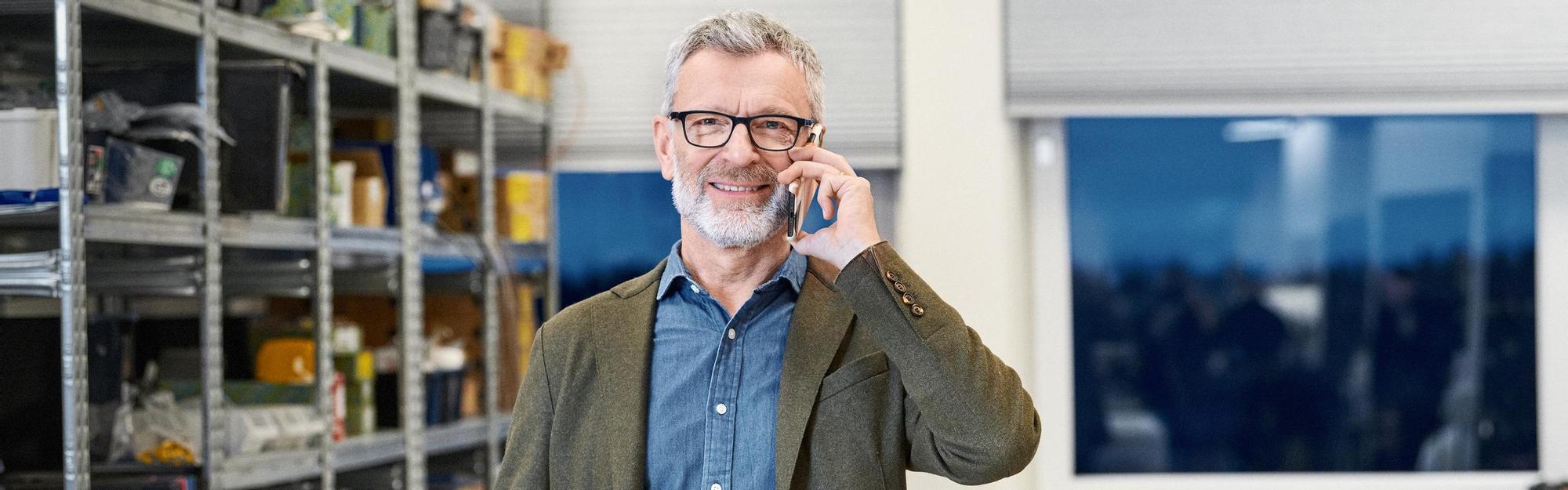 Man standing at a company talking in his mobile