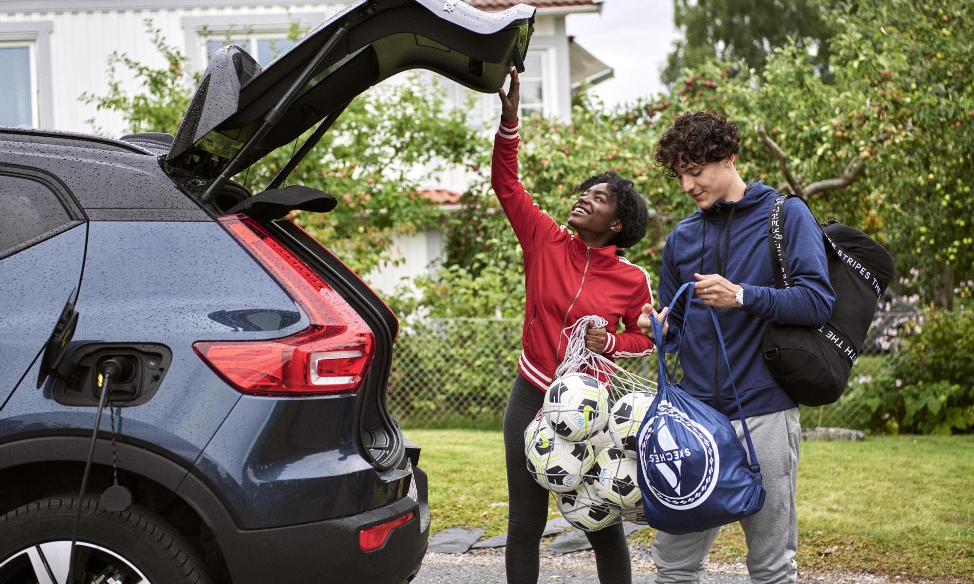 Young adults charging an electric car after soccer practice