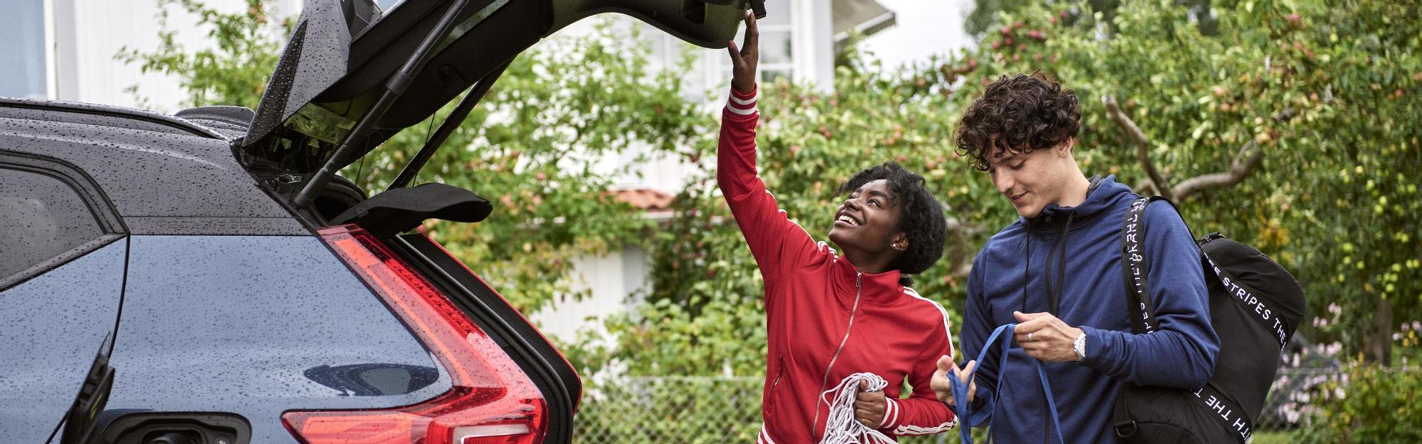 Young adults charging an electric car after soccer practice