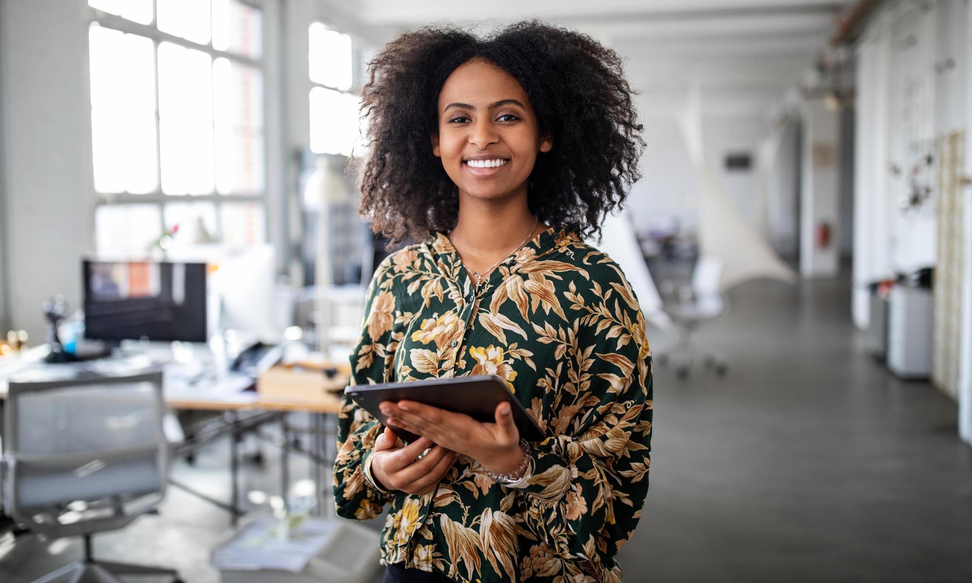 Woman standing with digital tablet in office