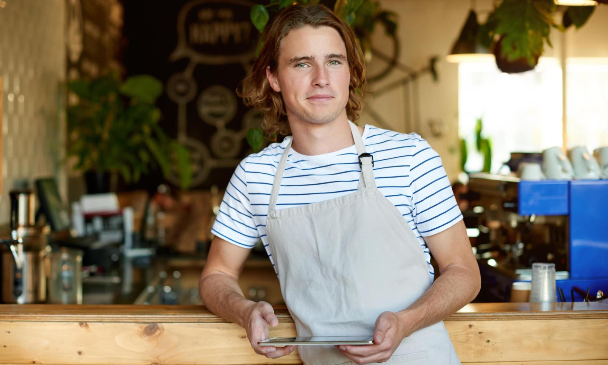 Barista som hänger på disken med en ipad i handen