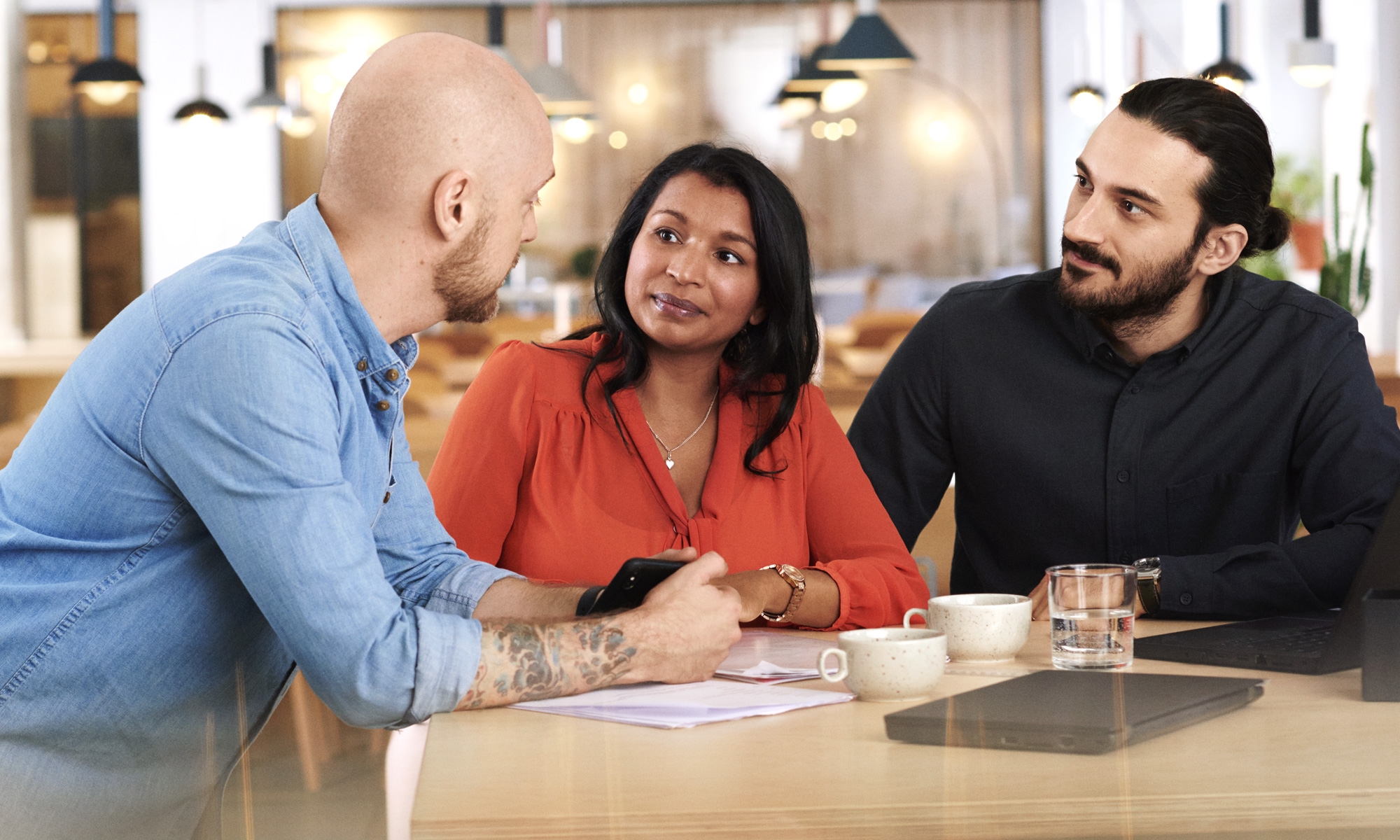 Tre kollegor diskuterar något på kontoret